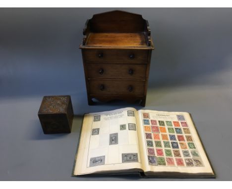 A Victorian miniature chest of drawers, tea caddy and book of stamps.