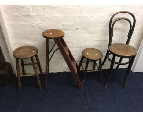 Two wooden stools, a hoop backed chair and a ladder stool.