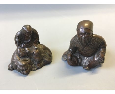 Two Chinese bronze wise men figurines, one on temple dog. Height 6cm and 6.5cm.