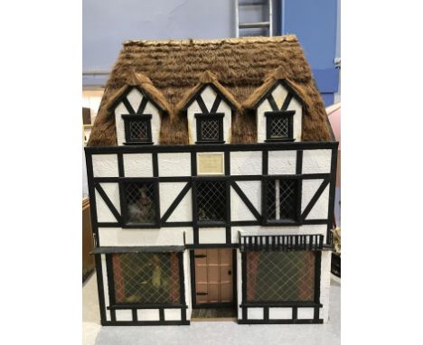 A large thatched black and white cottage Doll's House, 'The Hunting Lodge of Henry VIII', 68cm wide