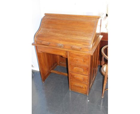 A 1930's small oak tambour desk, with four drawers, 89cm wide