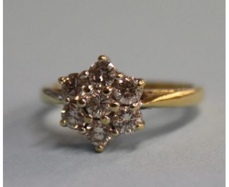 An 18ct gold, seven stone 0.75ct diamond cluster ring, size 'K'