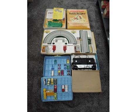 A Adman Model 2000 Grandstand TV Game, Subbuteo Table Rugby Set, Matchbox Motorised Motoway and a Matchbox Carry Case contain