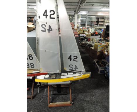 A radio controlled model sail boat GBR2242 with sail and spare sail, on wooden stand, height approx 210cm