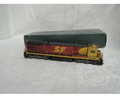 A Atlas HO scale plastic BNSF Locomotive 5184, custom painted by Ken Eagleshaw in a Overlands Models Inc Drive System box
CON