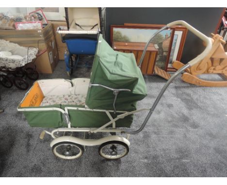 A 1960's TanSad Dolls Pram genuine model 322 having green canopy hood with cream interior on twin axle frame
