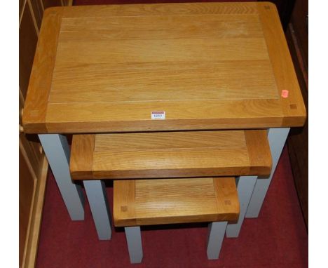 A contemporary light oak and grey painted nest of three occasional tables, the largest w.65cm