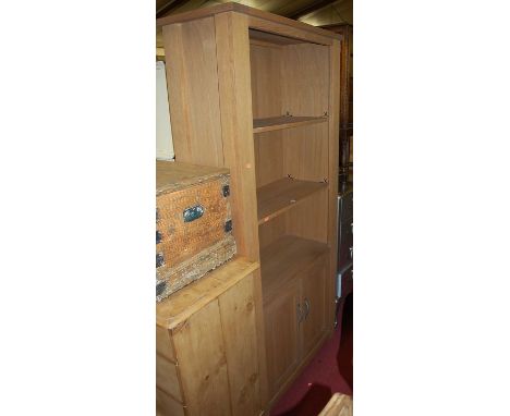 A contemporary light oak freestanding open display shelf having twin lower cupboard doors, width 90cm