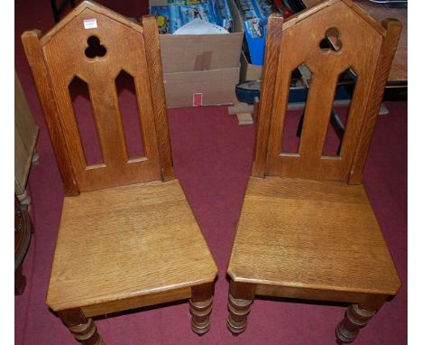 A pair of Victorian Gothic revival oak panel seat hall chairs, each having pierced backsCondition report: Chairs sit well.Goo