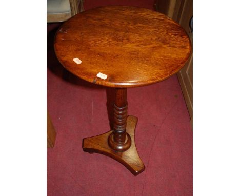 A pair of contemporary oak circular fixed top pedestal tripod occasional tables, raised on turned supports to triform bases, 