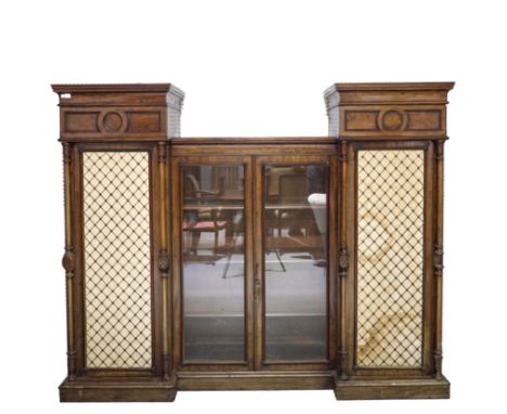 A REGENCY MAHOGANY BREAKFRONT SENTRY WARDROBEWith central glazed cupboards flanked by brass grilled cupboard doors, 215cm wid