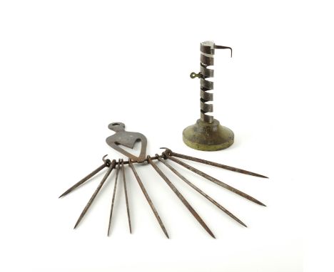A FRENCH WROUGHT IRON 'RAT DE CAVE' EJECTOR CANDLESTICK TOGETHER WTH A WROUGHT IRON HANGER AND SKEWERS  (2)19th Century 
With