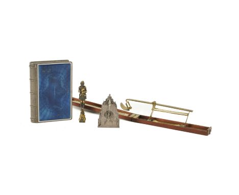 A SILVER-PLATED ENAMEL STATIONERY BOX IN THE FORM OF A BOOK AND OTHER DESK ITEMS INCLUDING A GOTHIC STYLE TIME-PIECE (4)Late 