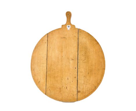 A LARGE PINE CIRCULAR BREAD PEELWith integral handle, 65cm wide; 88cm long
