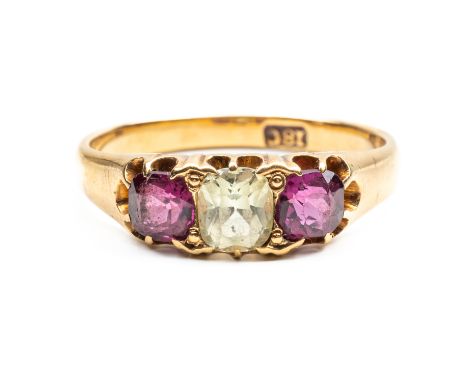 A GOLD, CHRYSOLITE AND GARNET THREE STONE RINGClaw set with the chrysolite at the centre between two cushion shaped garnets d