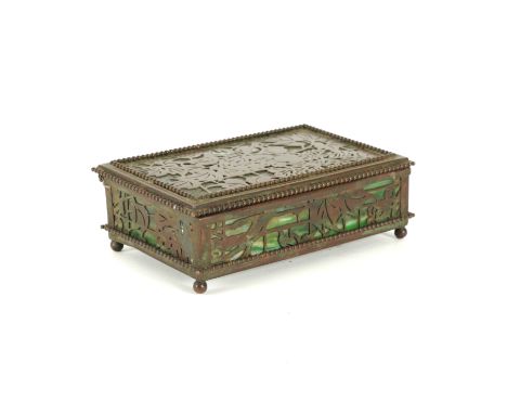 TIFFANY STUDIOS, NEW YORK: AN ARTS & CRAFTS BRONZE AND MARBLED GREEN GLASS BOXCirca 1900
With a flowering leafy pattern, stam