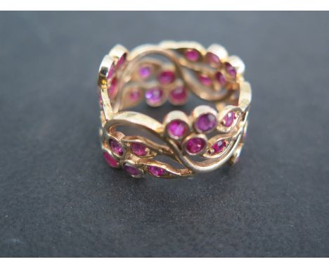 A 9ct yellow gold dress ring set with thirty rubies in a foliate formation ring size O - clean and bright - approx weight 5.6