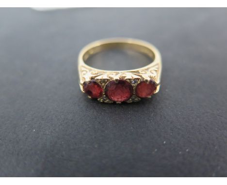 An 18ct gold three stone garnet ring size P - approx weight 5 grams - minor usage marks