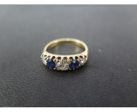 A very attractive 18ct gold diamond and sapphire five stone ring - the central diamond approx 0.4ct, total diamond weight app