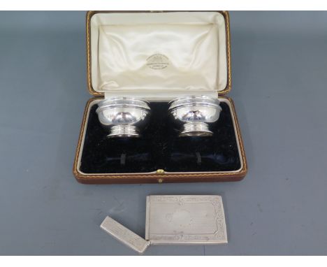 A pair of silver hallmarked salts with blue glass liners and a silver card case with engine turned decoration Birmingham 1883