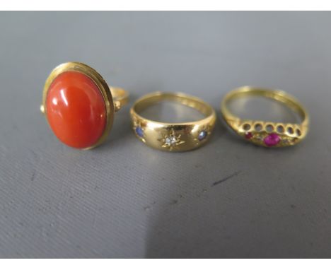 Three 18ct gold rings, one with large agate to shoulder, one with two sapphires and small diamond to shoulder, one with rubie