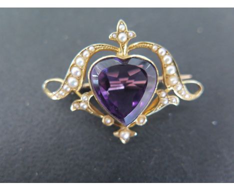 A 15ct gold amethyst and seed pearl brooch the heart shaped amethyst measures 15mm by 14mm - brooch width 40mm - stamped 15ct