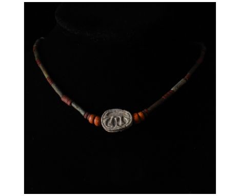 Ancient Egyptian. Striking restrung necklace comprising red, grey and brown hardstone beads of circular and annular form, arr