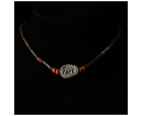 Ancient Egyptian. Striking restrung necklace comprising red, grey and brown hardstone beads of circular and annular form, arr