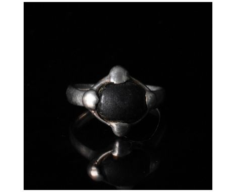 C. 900 AD, Viking Age. A silver ring with a D-shaped hoop and a round bezel set with a dark coloured gem secured by four addi