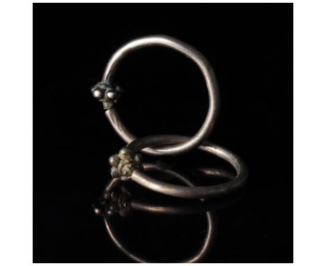 ca. 300 - 100 BC, Celtic Iron Age. Pair of silver earrings comprising circular hoops culminating in stylised fruit motif, per