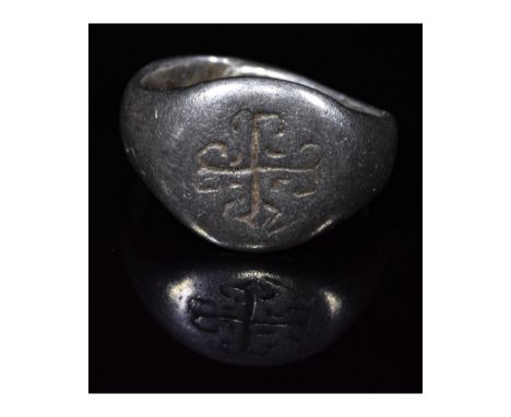 1000-1500 AD, Medieval Crusader period. Silver ring with D-shaped hoop and circular bezel featuring an elaboarate incised cro