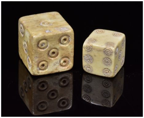 1-300 AD, Roman. Pair of Roman bone dice of differing size. The larger dice features a dot-in-circle pip design and the small