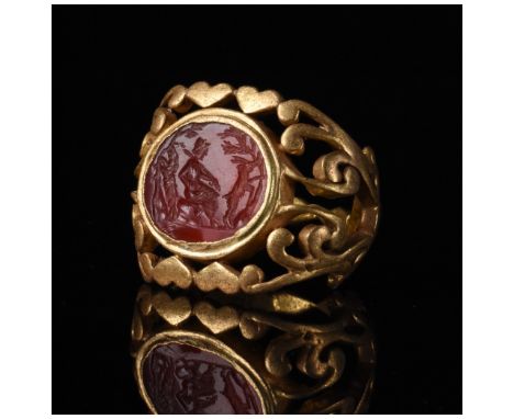 c. 1-300 AD. Roman. A beautiful red stone intaglio with an incised image of a satyr and goats set into a later heavy gold rin