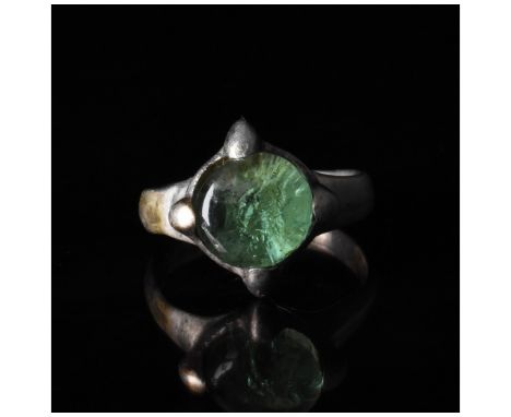 C. 900 AD, Viking Age. A silver ring with a circular hoop and a round bezel set with a green gem secured by four additional '