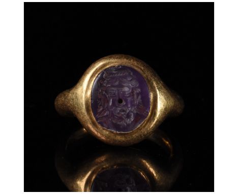 c. 1-300 AD. Roman. A Roman elliptical amethyst intaglio bearing an incised portrait of Zeus set into a later gold ring with 