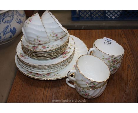 An Edwardian Tea service comprising six trios and a cake plate in floral decoration and fluted spiral body with gilt borders,