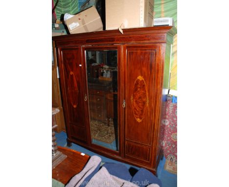 A superb Edwardian Mahogany three door Compactum Wardrobe, with moulded cornice over inlaid frieze, the central wide door hav