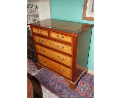 A good reproduction mixed wood, Georgian style Chest of two short, over three long graduated Drawers, the top having a centra
