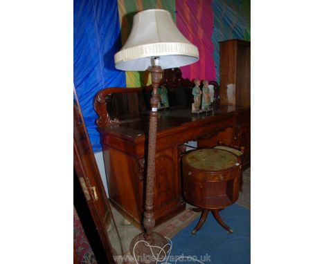 An elegant Oak Standard Lamp with cream conical shade, the turned pedestal base with intricate floral carving throughout, on 