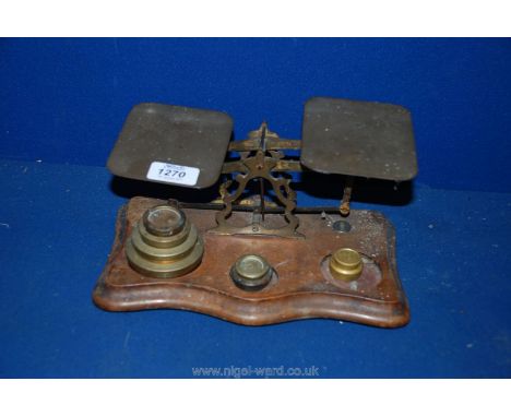 A set of Postal Scales on wooden stand with various weights.