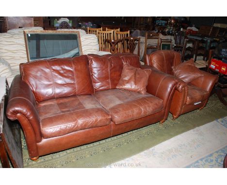 A modern two seater Lounge Sofa and matching Armchair with scatter cushion, in stitched brown leather and standing on bun fee