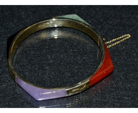 A 9ct gold multi stone hinged bangle, inset  with jade and other specimen stone panels, compression clasp, safety chain, mark