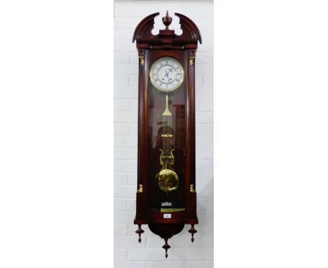 Modern wall clock with a broken pediment, urn finial and brass capped pilasters, an enamel dial with Roman numerals inscribed