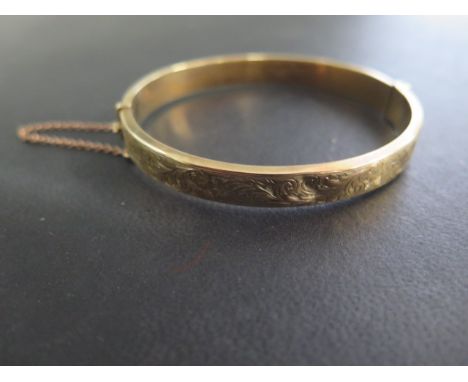 A hallmarked 9ct yellow gold hollow hinged bangle, 6cm x 6.5cm, approx 9.7 grams, minor denting but reasonably good and catch