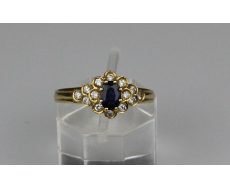 An 18ct gold sapphire and diamond cluster ring, the claw set central oval faceted sapphire, estimate approx weight 0.40ct, su