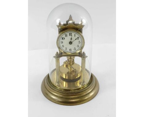 A 20th century table clock, in a glass dome and standing on brass base, 28cm high 