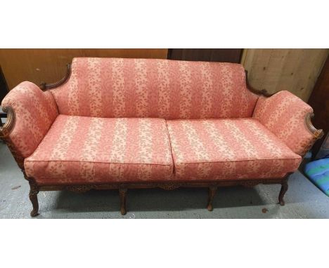 An early 20th century carved walnut framed two seater sofa, with reeded arms and back, standing on four cabriole legs 