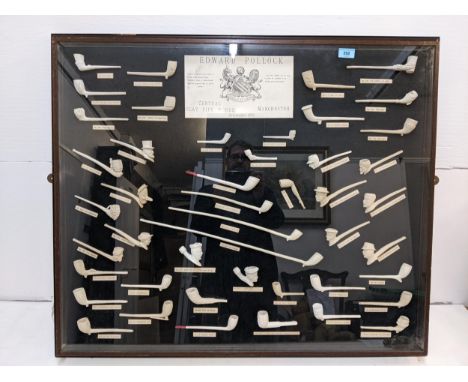 A display of forty six smoking pipes with a plaque Edward Pollack Central Clay Pipe Works in a display case 83cm x 98cm Locat