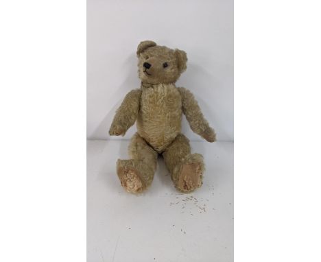 A 1920's Farnell teddy bear with golden coloured mohair, kapok and wood stuffed, with a black stitched mouth and nose, black 