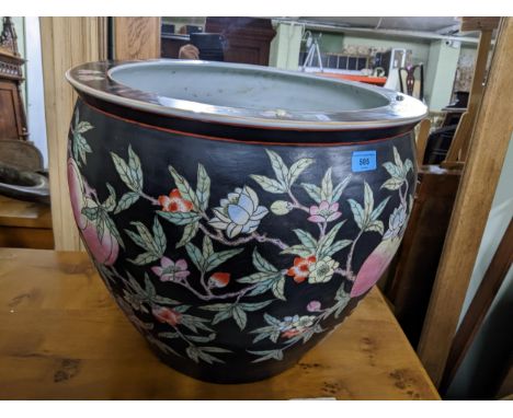 A large Chinese famille noir jardiniere bowl decorated with peaches on flowering branches against a black ground to the exter